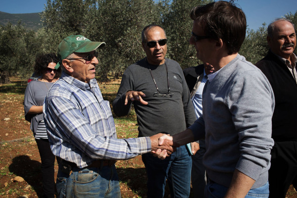 Olive farmer Abu Naim (left) shakes hands with Dave Harden, USAID mission director in the Palestinian Authority