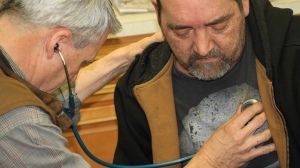 Dr. Rob Marsh examines truck driver Robert Day at Marsh's clinic in Raphine, Va. Day said he used to be healthy. but now smokes two packs of cigarettes a day and doesn't get enough exercise. (Meagan Fitzpatrick/CBC News)
