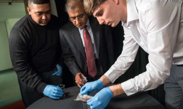 Bharat Bhushan (Ohio Eminent Scholar in Mechanical Systems, center), research assistant Dave Maharaj (left) and postdoctoral researcher Philip Brown (right) -- all of The Ohio State University -- demonstrate new technology they have developed for separating oil from water. Credit: Jo McCulty, courtesy of The Ohio State University.