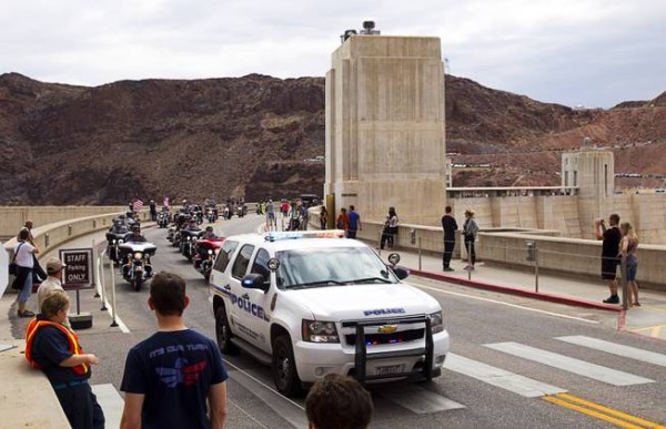 A Dam Police vehicle leads hundreds of motorcyclists over Hoover Dam during the annual Flags Over the Dam parade Sunday, May 24, 2015, from the dam to Southern Nevada Veterans Memorial Cemetery.