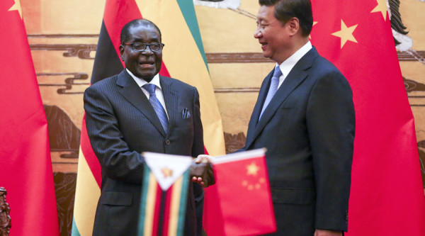 Zimbabwe's President Robert Mugabe (L) and his Chinese counterpart Xi Jinping shake hands during a signing ceremony at the Great Hall of the People in Beijing August 25, 2014. REUTERS/Diego Azubel/Pool (CHINA - Tags: POLITICS) - RTR43NIT