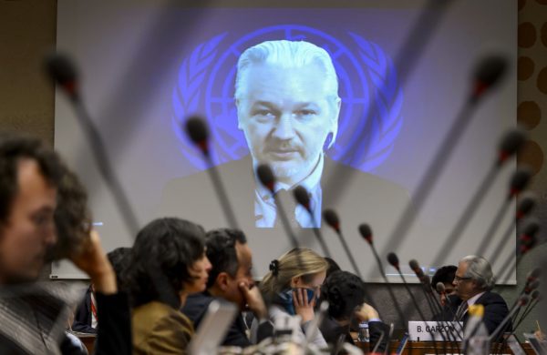 WikiLeaks founder Julian Assange is seen on a screen speaking via web cast from the Ecuadorian Embassy in London during an event on the sideline of the United Nations (UN) Human Rights Council session on March 23, 2015 in Geneva. Assange took refuge in June 2012 in the Ecuadorian Embassy to avoid extradition to Sweden, where he faces allegations of rape and sexual molestation, which he strongly denies. AFP PHOTO / FABRICE COFFRINI (Photo credit should read FABRICE COFFRINI/AFP/Getty Images)